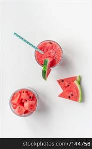 Creative scandinavian style flat lay top view of fresh watermelon slices smoothie drink in glass on white table background copy space. Minimal summer fruits concept for blog or recipe book