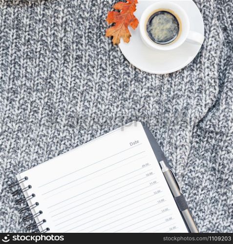 Creative square autumn flat lay overhead top view stylish home workspace planner organizer coffee cup cozy gray knitted plaid background copy space. Fall season template for feminine blog social media