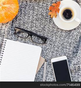 Creative square autumn flat lay overhead top view stylish home workspace smartphone notebook coffee cup cozy gray knitted plaid background copy space. Fall season template feminine blog social media