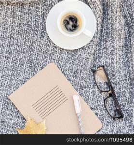 Creative square autumn flat lay overhead top view stylish home workspace with notebook coffee cup cozy gray knitted plaid background copy space. Fall season template for feminine blog social media