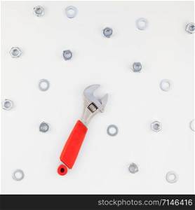Creative square Flat lay of metal nuts and spanner on white background. Repair or improvement top view concept pattern.