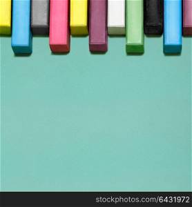 Creative still life of multicolored chalks arranged in a row like piano keys.