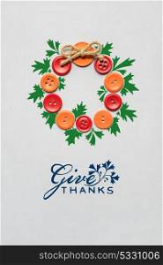 Creative thanksgiving day concept photo of a wreath made of buttons on grey background.
