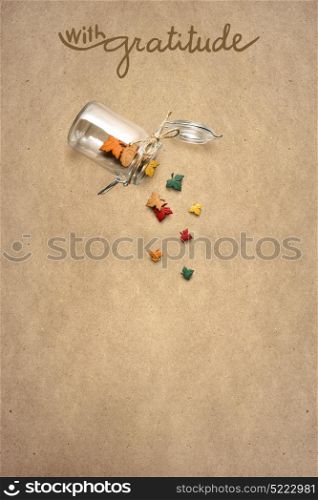 Creative thanksgiving day concept photo of leaves falling from the bottle on brown background.