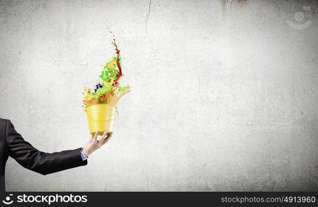 Creative thinking. Close up of businessman hand holding bucket with paint