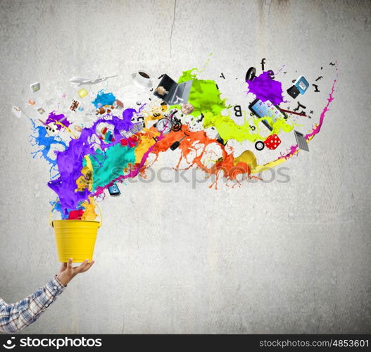 Creative thinking. Close up of hand splashing colorful paint from bucket