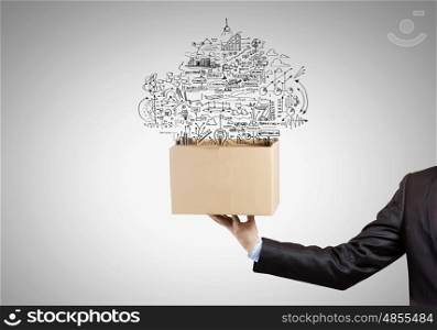 Creative thinking. Man holding carton box with business sketches
