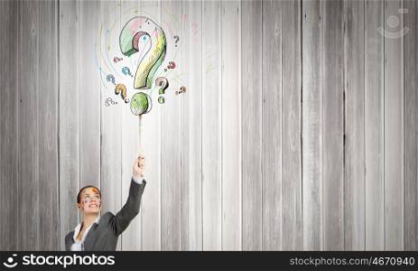 Creative thinking. Young attractive businesswoman painting question mark with paint brush
