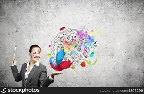 Creative thinking. Young attractive businesswoman with paint brush and colorful business sketches