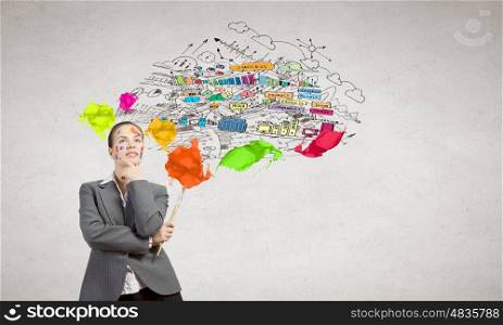 Creative thinking. Young attractive businesswoman with paint brush and colorful business sketches