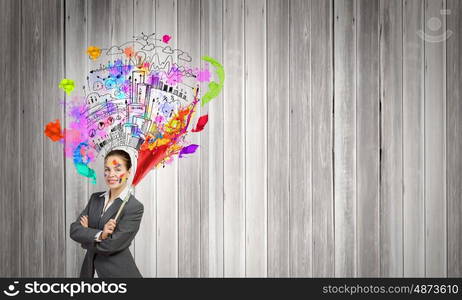 Creative thinking. Young attractive businesswoman with paint brush and colorful business sketches