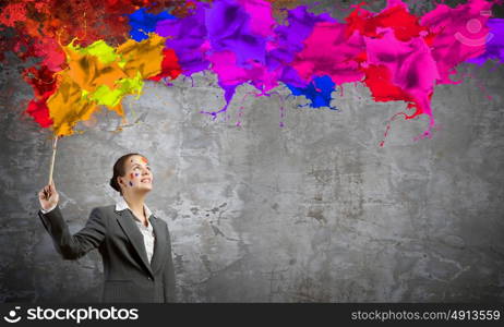 Creative thinking. Young attractive businesswoman with paint brush in hand