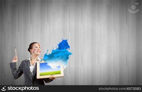 Creative thinking. Young attractive woman in suit with paint brush in hand
