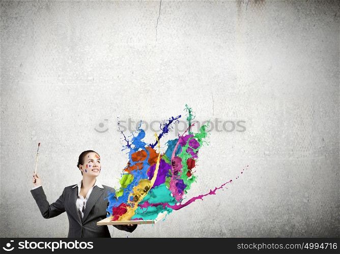 Creative thinking. Young attractive woman in suit with paint brush in hand