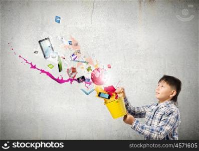 Creative thinking. Young boy splashing colorful paint from bucket