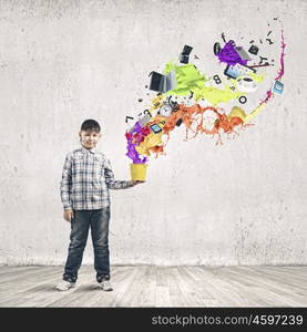 Creative thinking. Young boy splashing colorful paint from bucket