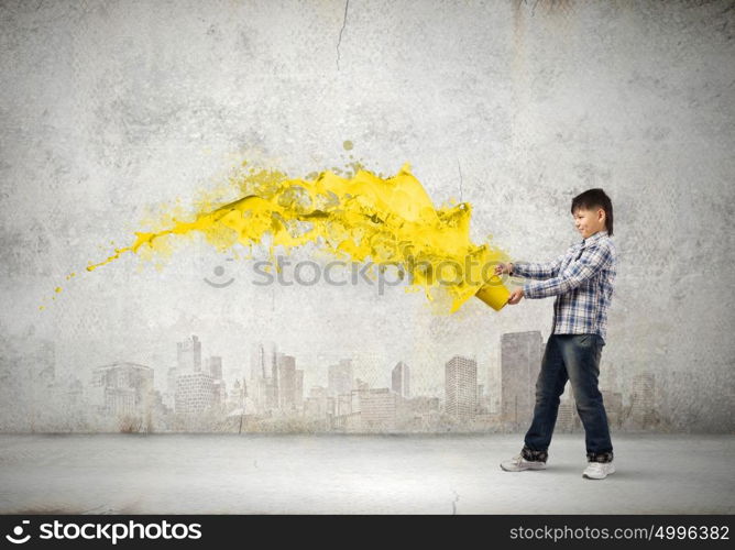 Creative thinking. Young boy splashing colorful paint from bucket