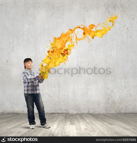 Creative thinking. Young boy splashing colorful paint from bucket