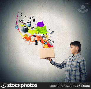 Creative thinking. Young boy splashing colorful paint from carton box