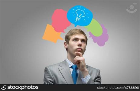 Creative thinking. Young businessman and colorful thoughts above her head