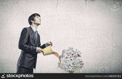 Creative thinking. Young businessman holding in hands yellow bucket