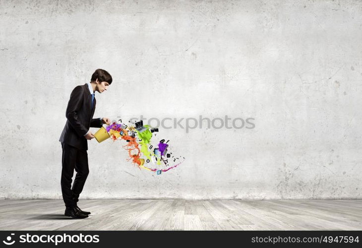 Creative thinking. Young businessman holding in hands yellow bucket