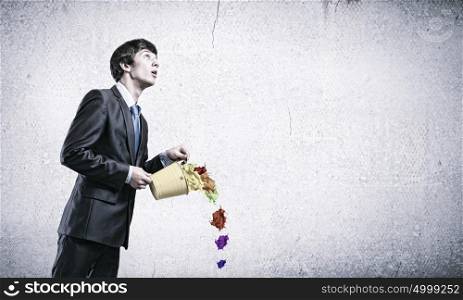 Creative thinking. Young businessman holding in hands yellow bucket