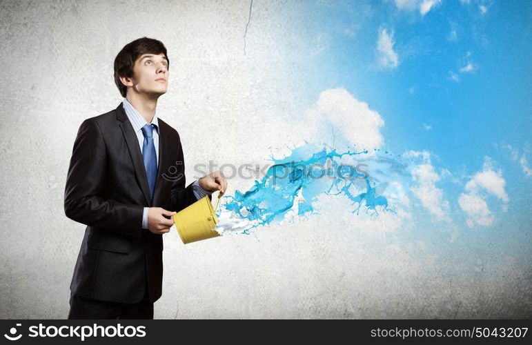 Creative thinking. Young businessman holding in hands yellow bucket