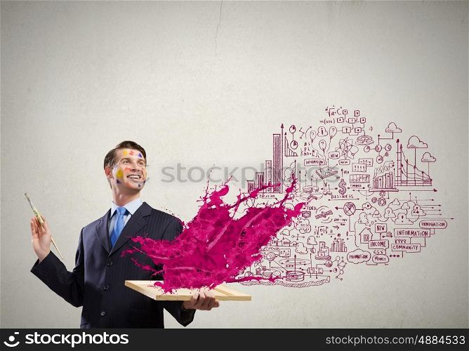 Creative thinking. Young handsome businessman with brush in hand