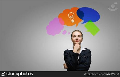 Creative thinking. Young thoughtful businesswoman and colorful speech bubbles above
