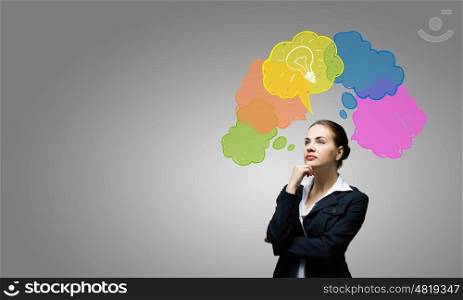 Creative thinking. Young thoughtful businesswoman and colorful speech bubbles above