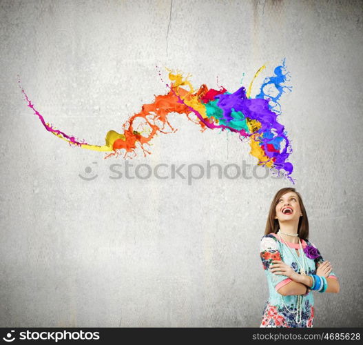 Creative thinking. Young woman in colorful dress looking at light bulb