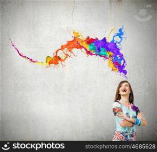 Creative thinking. Young woman in colorful dress looking at light bulb