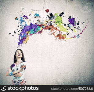 Creative thinking. Young woman in colorful dress looking at light bulb