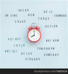 Creative top view flat lay of alarm clock with messages about delay or starting doing task copy space blue background minimal style. Concept of procrastination, time management in business and life