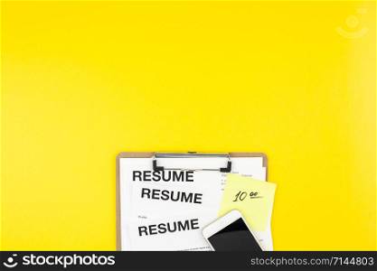 Creative top view flat lay of desk with resume documents copy space on bold yellow background in minimal style. Concept of new job, hiring recruitment process, new team members screening