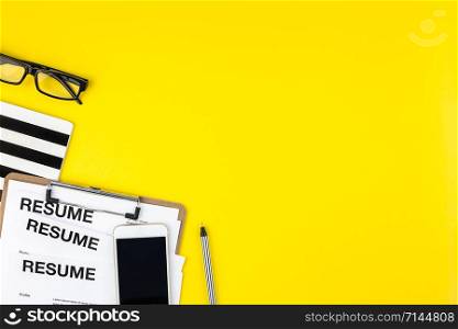 Creative top view flat lay of desk with resume documents copy space on bold yellow background in minimal style. Concept of new job, hiring recruitment process, new team members screening