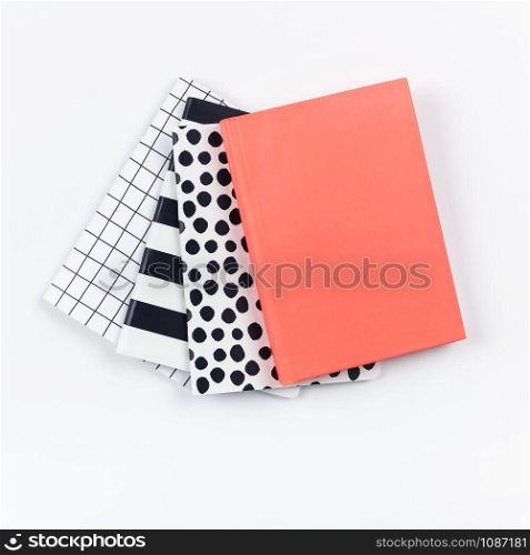 Creative top view flat lay of woman desk with different patterns notepads with copy space on white color paper background in minimal style. Template for feminine blog social media