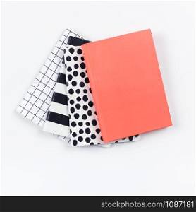 Creative top view flat lay of woman desk with different patterns notepads with copy space on white color paper background in minimal style. Template for feminine blog social media