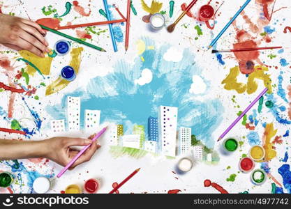 Creative urban design. Top view of people hands drawing urban concept with paints