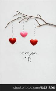 Creative valentines concept photo of a branch with hearts on white background.