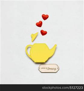 Creative valentines concept photo of a teapot made of paper on white background.