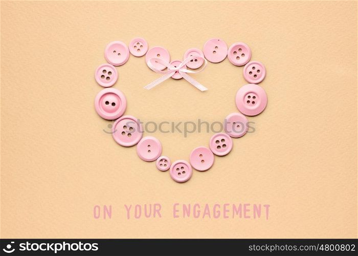 Creative valentines concept photo of heart made of buttons on brown background.