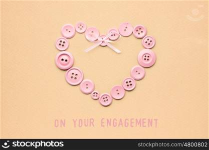Creative valentines concept photo of heart made of buttons on brown background.