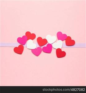 Creative valentines concept photo of hearts made of paper on pink background.