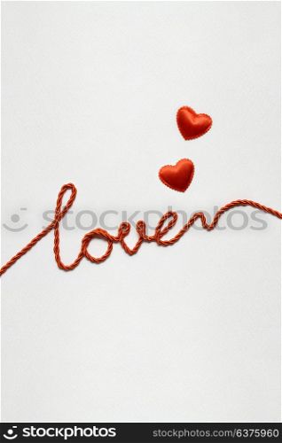 Creative valentines concept photo of hearts with love sign made of rope on white background.