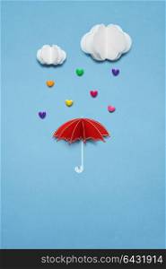 Creative valentines concept photo of umbrella with hearts raining down on white background.