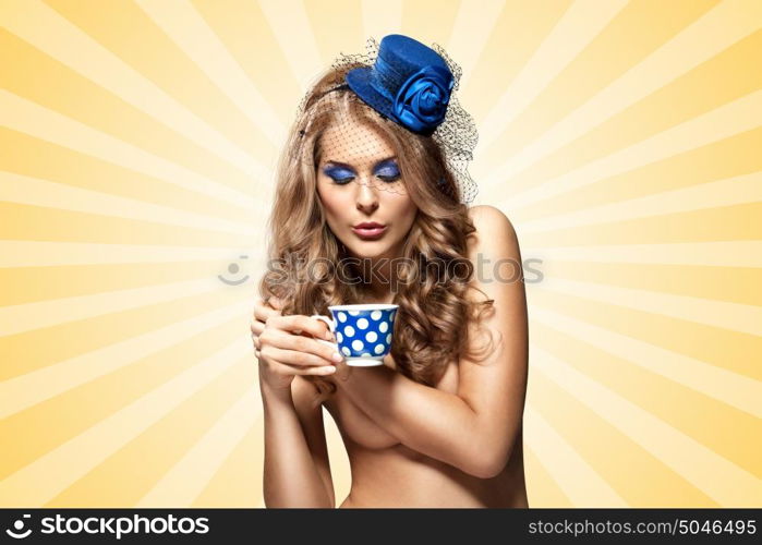 Creative vintage photo of a beautiful naked pin-up girl in a hat, drinking tea or coffee from a polka dot cup on colorful abstract cartoon style background.