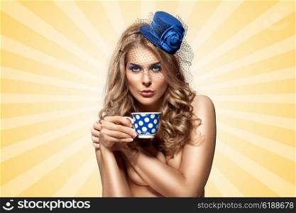 Creative vintage photo of a beautiful naked pin-up girl in a hat, drinking tea or coffee from a polka dot cup on colorful abstract cartoon style background.