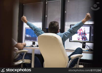 creative worker, photo editor working on graphic tablet at his desktop computer at small startup office